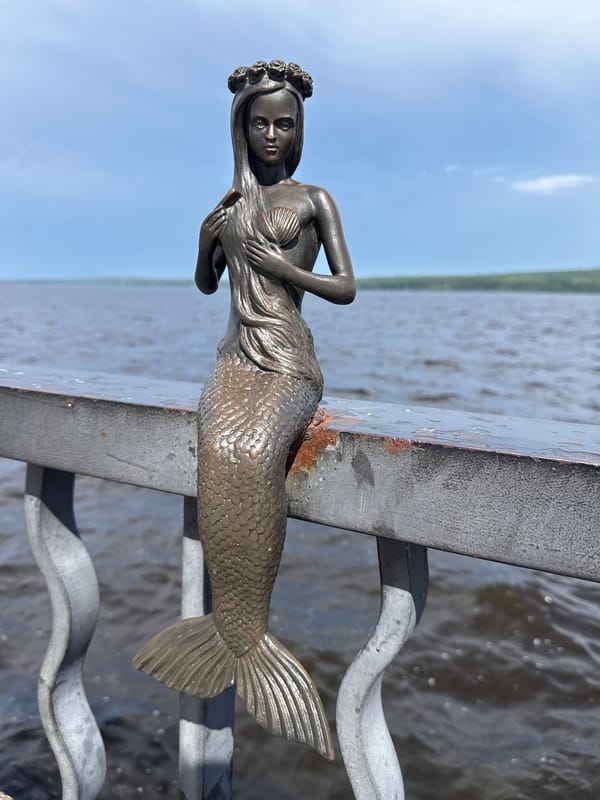 Sunny morning at a lakefront promenade with a mermaid statue