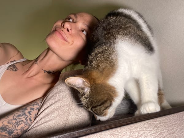 Tattooed woman holds multicolored cat in Pervomaysky, Russia