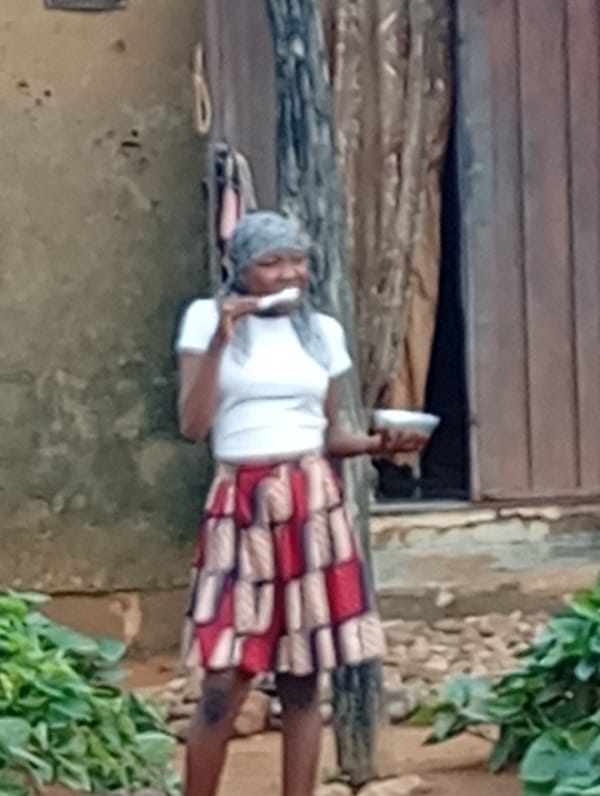Woman eating breakfast outdoors in Yelwa, Nigeria