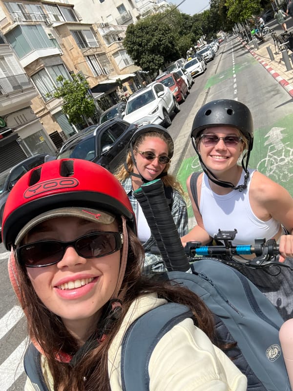 Three women on scooters take selfie in Tel Aviv