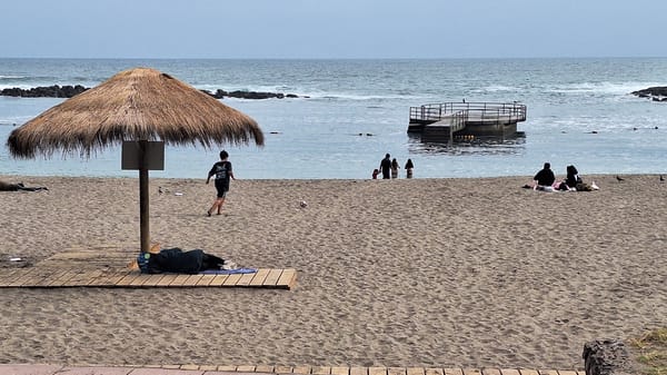 Cloudy day at Arica's beach, locals and visitors along the shore