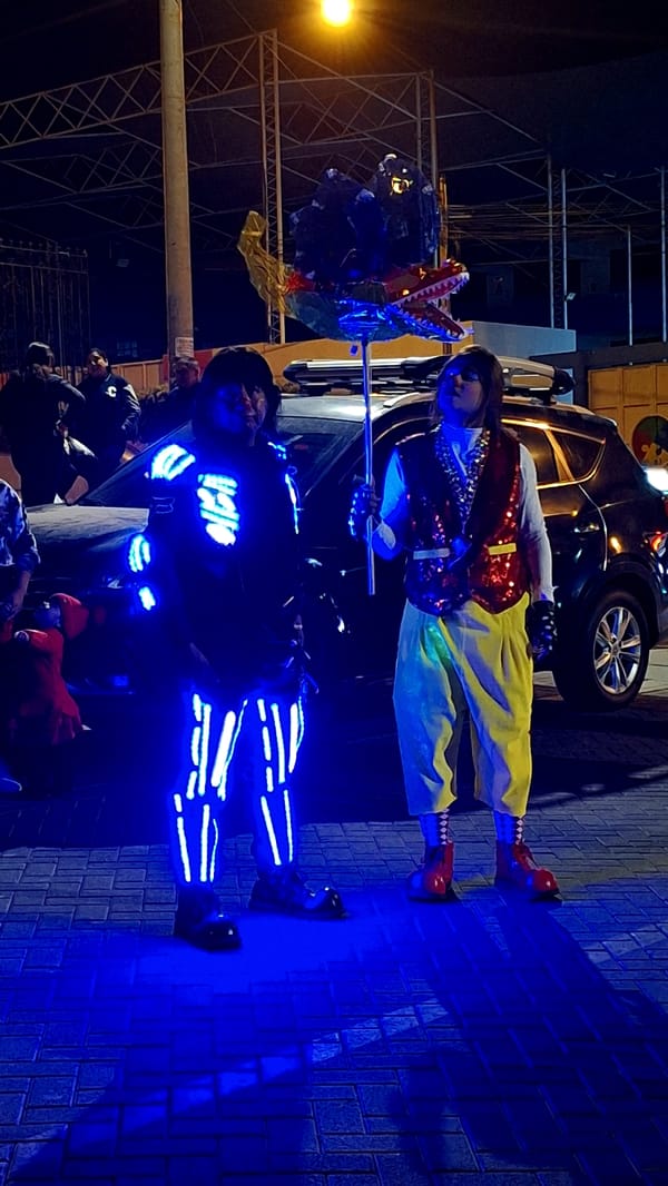 Costumed street performers entertain crowds during nighttime Miraflores celebration