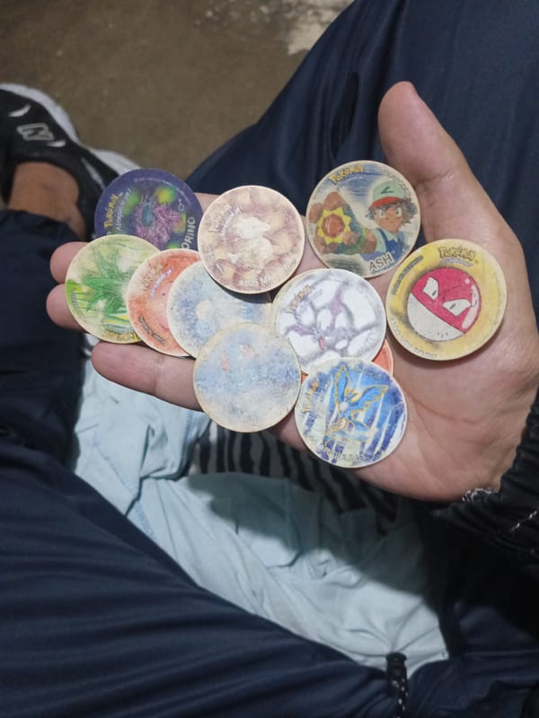 Person displays vintage Pokemon and Dragon Ball Z pogs
