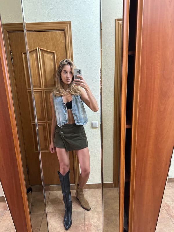 Mirror selfie in a Moscow bedroom, denim vest and corduroy skirt