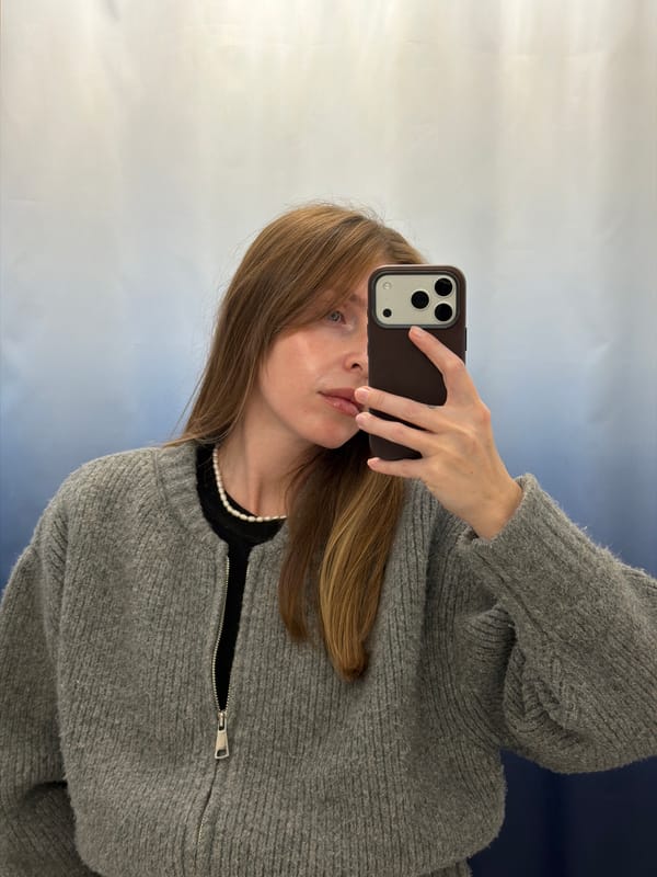 Woman takes selfie in Jerusalem wearing grey sweater