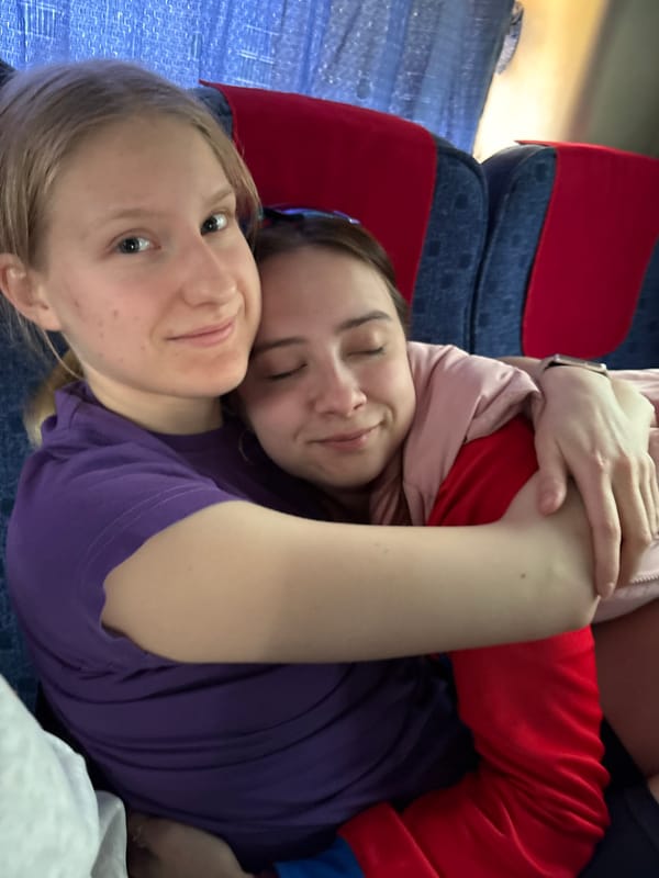 Two women rest together on bus in Russian village