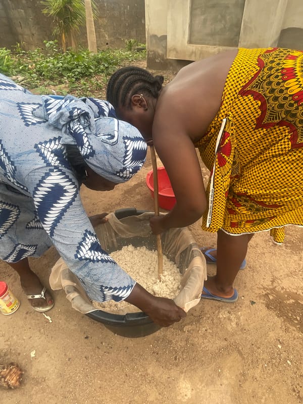 Women process grains outdoors in Akwanga, Nigeria