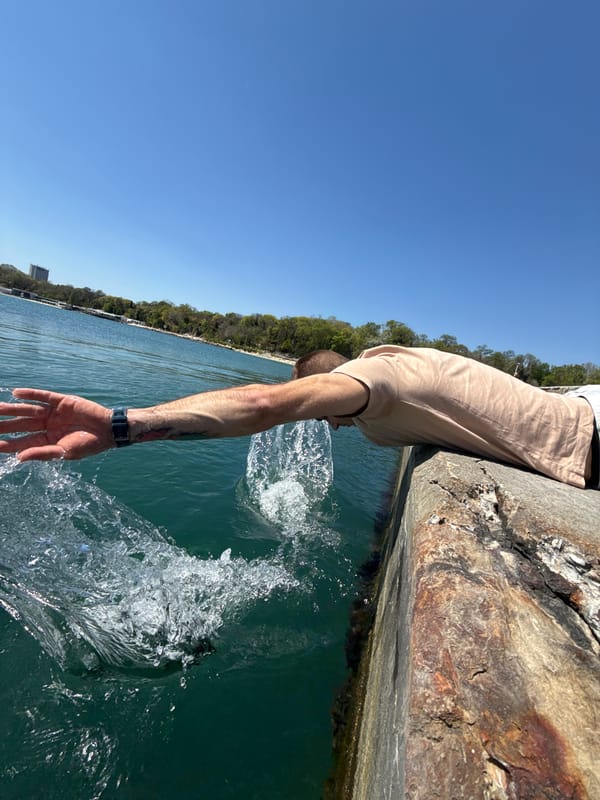Man touches Black Sea water from pier in Varna