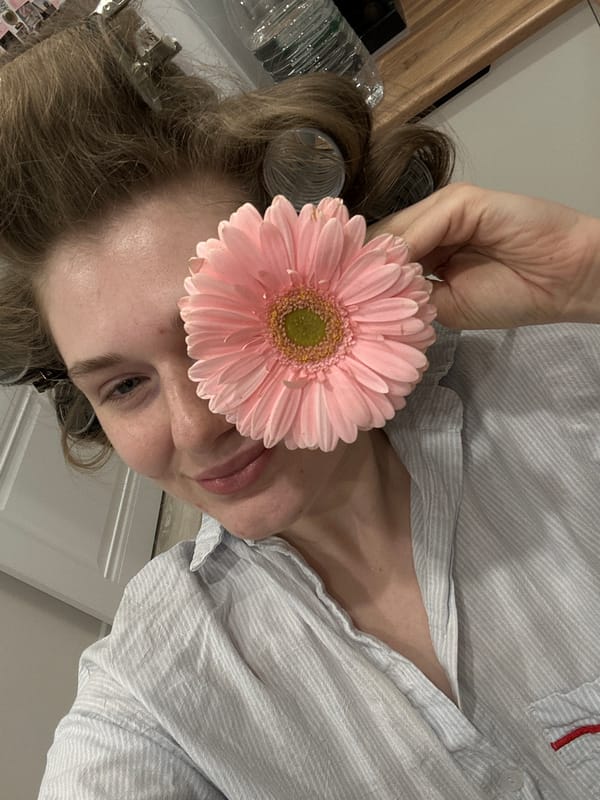 Woman poses with pink flower in Kazan interior