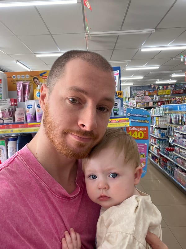 Man holds child in Thailand convenience store early morning