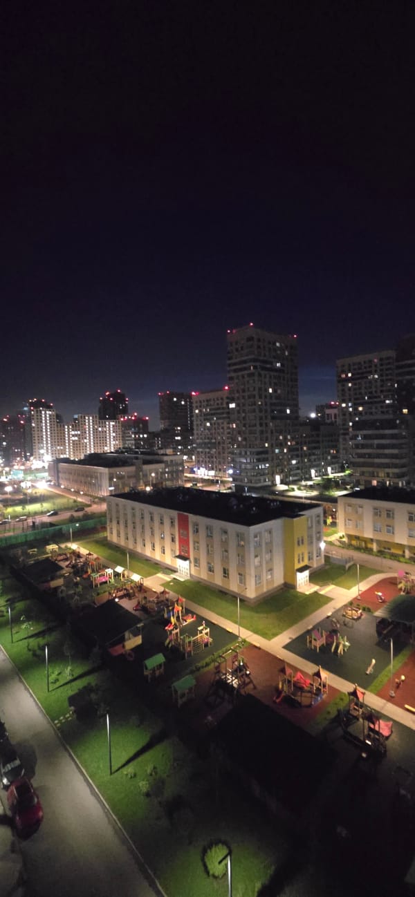 Aerial night views over a lit-up urban residential complex
