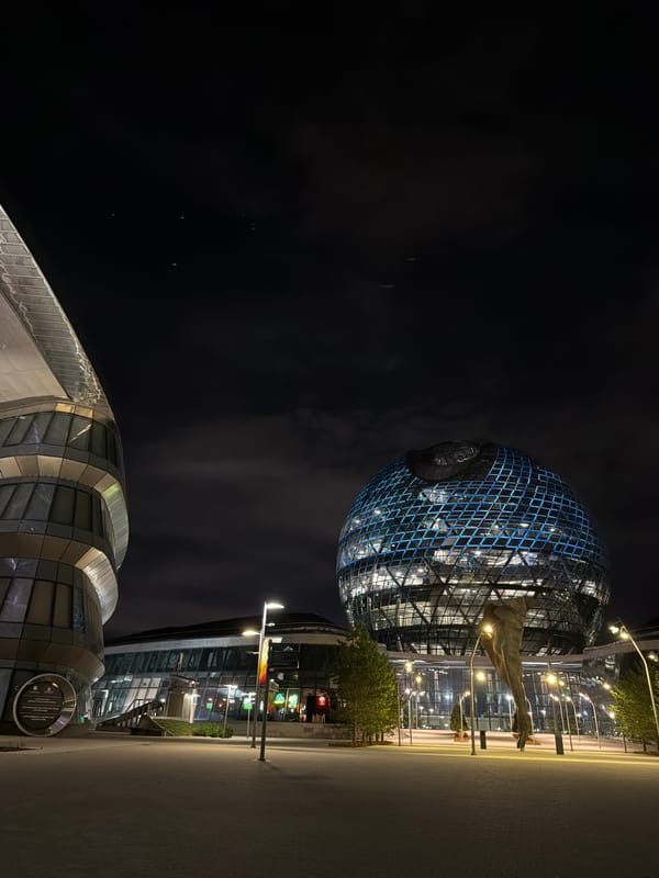 Astana at night: Nur Alem sphere, plaza sculpture, and crescent moon