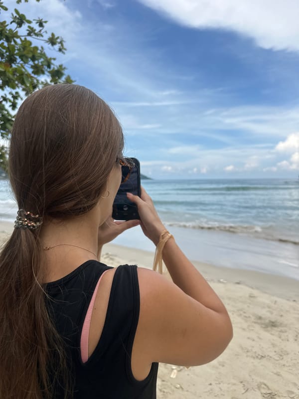 Coffee and phone in hand on Karon Beach