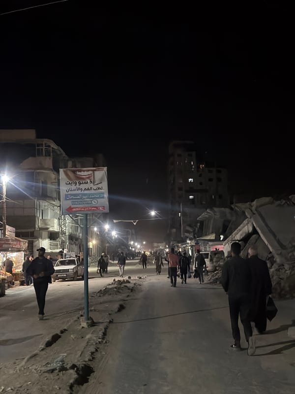 Pedestrians navigate damaged Gaza City streets at night