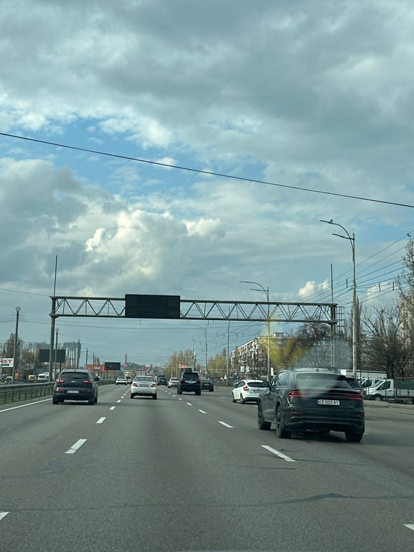 Multi-lane highway traffic observed in Kyiv with overhead infrastructure