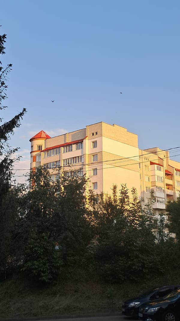 Mixed residential buildings on a clear afternoon, street level.
