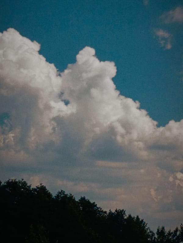 Cumulus clouds rolling through a deep blue afternoon sky
