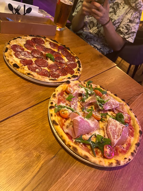 Artisanal pizzas and neon signs at a Krakow restaurant