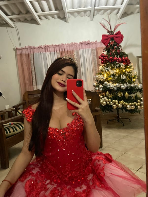 Woman in formal red gown takes mirror selfies in Venezuela