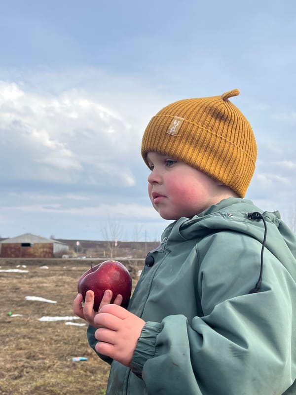 Child plays outdoors during spring morning in Павловка, Russia