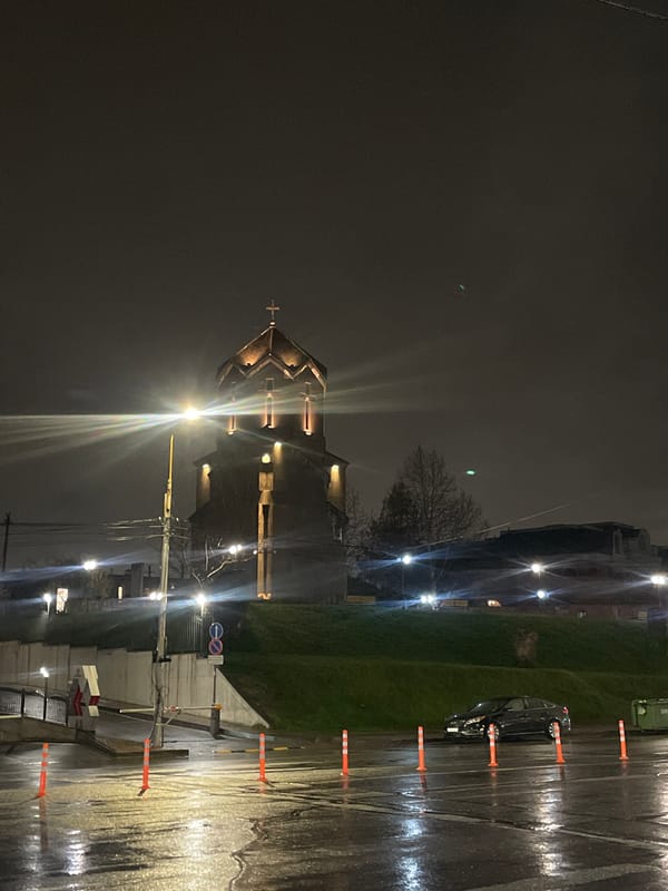 Red Mercedes parked on wet Yerevan street during evening