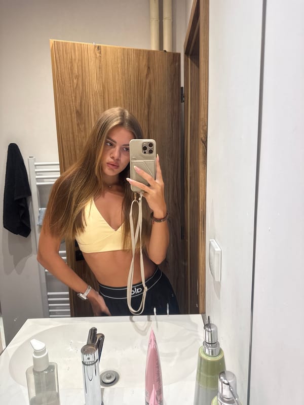 Mirror selfie in a Plovdiv bathroom, athletic outfit, July 2026