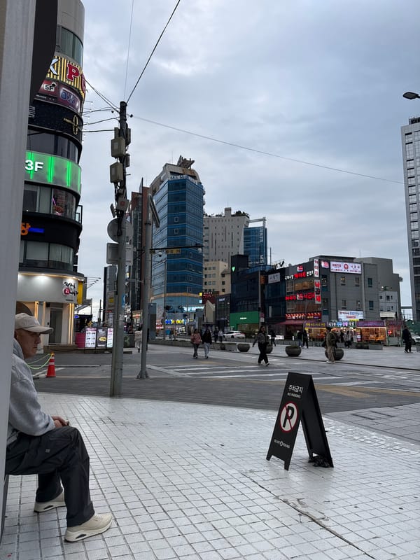 Person lying on sidewalk in Busan commercial district