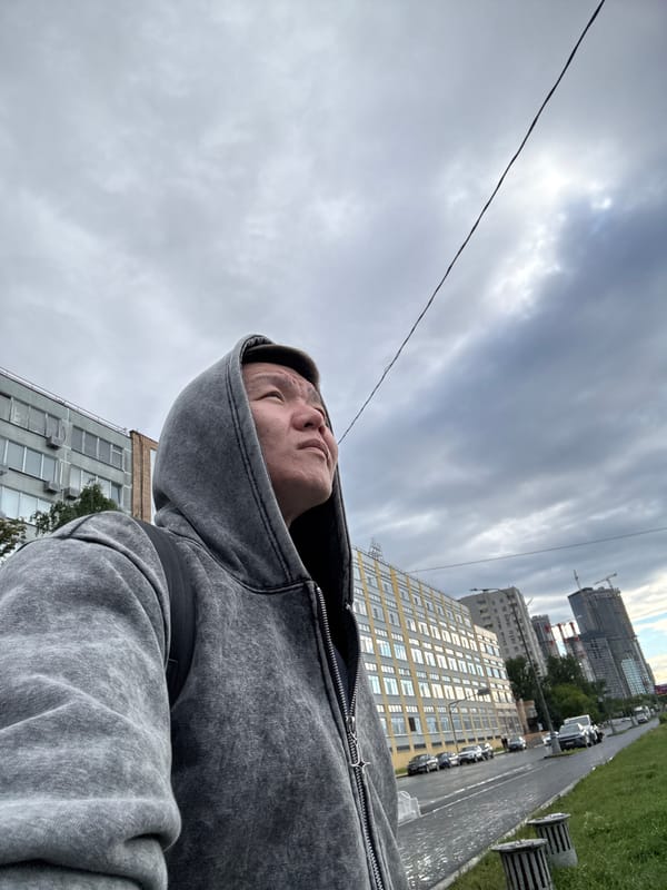 Low-angle street portrait in Dolgoprudny, grey hoodie in frame