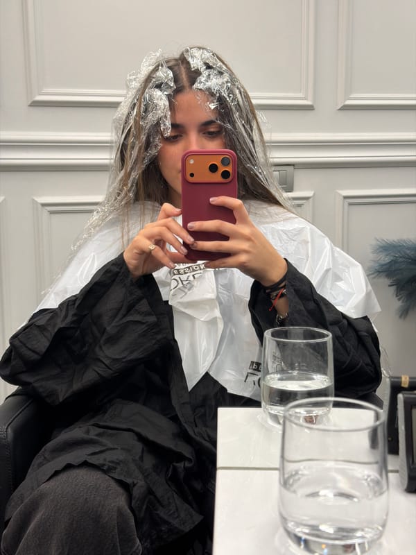 Woman takes mirror selfie during hair treatment in Milan