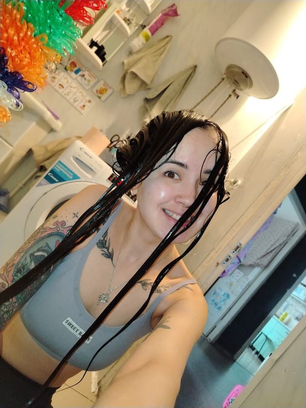 Person Takes Bathroom Selfie in Gray Sports Bra