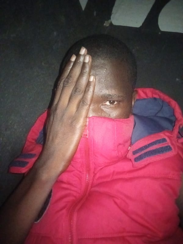 Person in red jacket observed covering face indoors