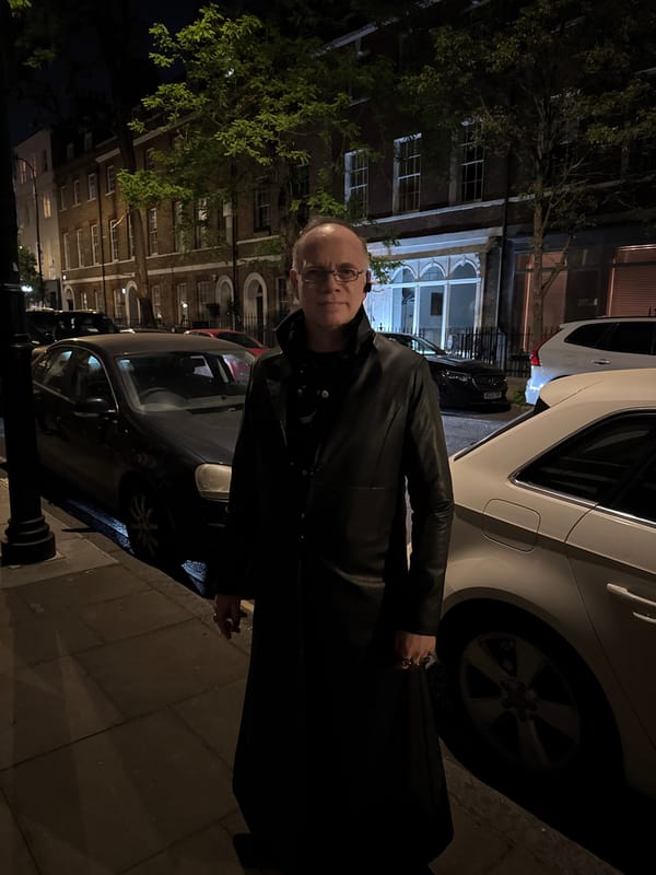 Man in glasses observed standing on London sidewalk at night