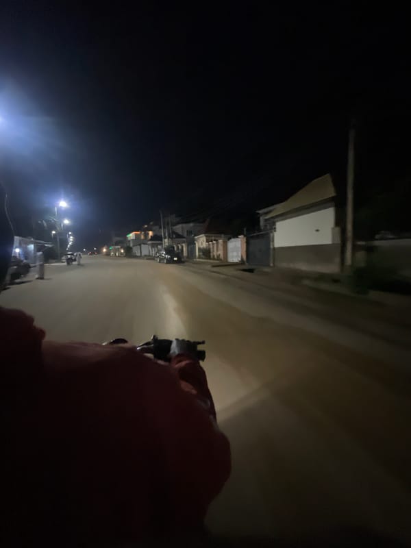 Motorcycle rider travels through nighttime Abuja streets