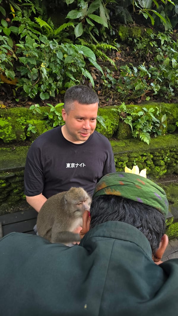 Tourists pose with monkeys at Ubud sanctuary