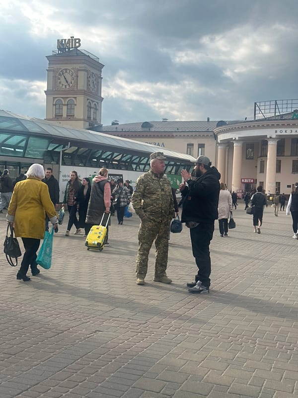 Pedestrians with luggage gather in Kyiv public square