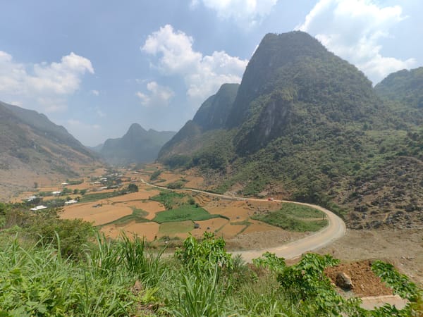 Tourists motorcycle through scenic Vietnamese mountain valley taking selfies