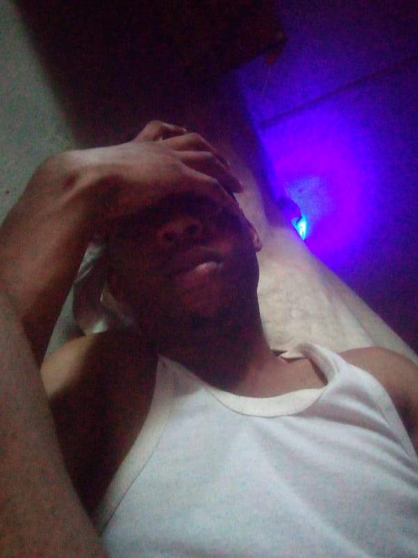 Person rests, drinks in dimly lit room