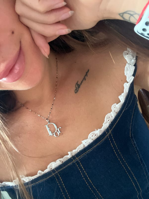 Person with neck tattoo and silver jewelry observed