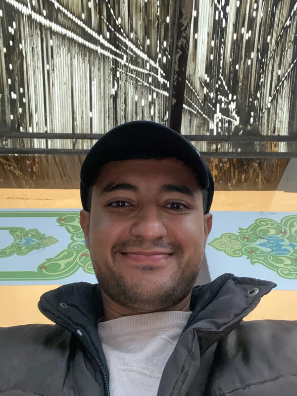 Man photographed against ornate wall in historic Bukhara