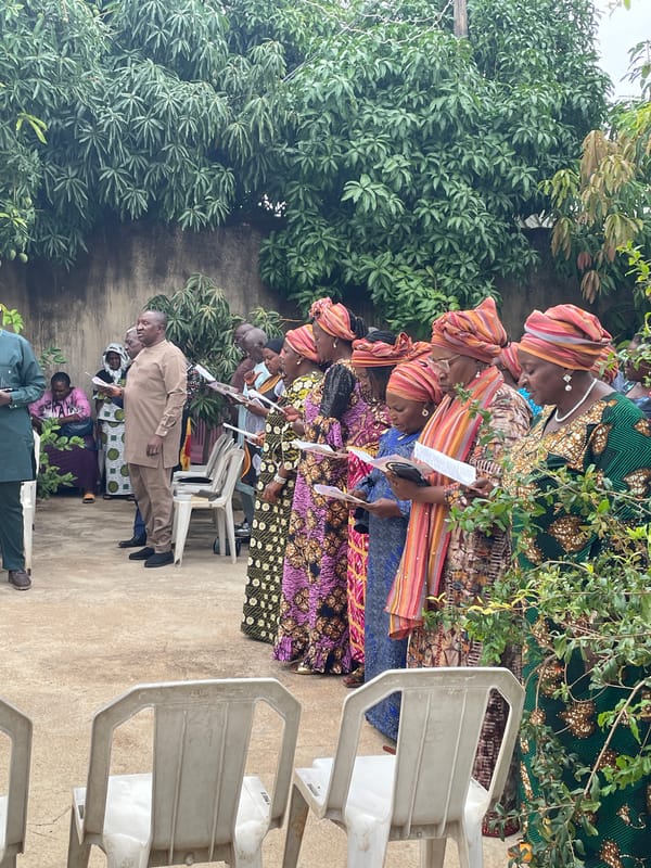 Community gathering observed in green outdoor setting in Jos