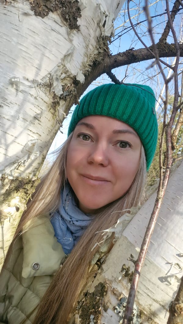 Woman rests under birch tree in rural Russia
