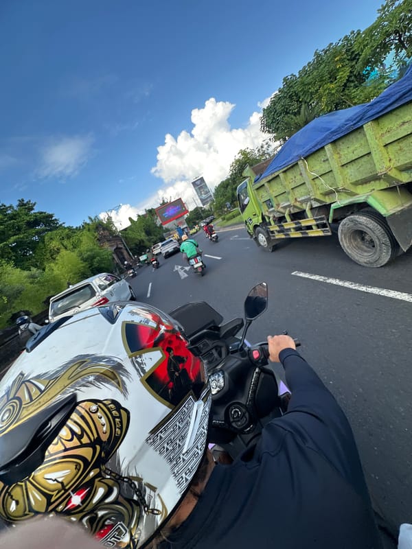 Motorcyclist with ornate helmet rides through Kuta, Indonesia