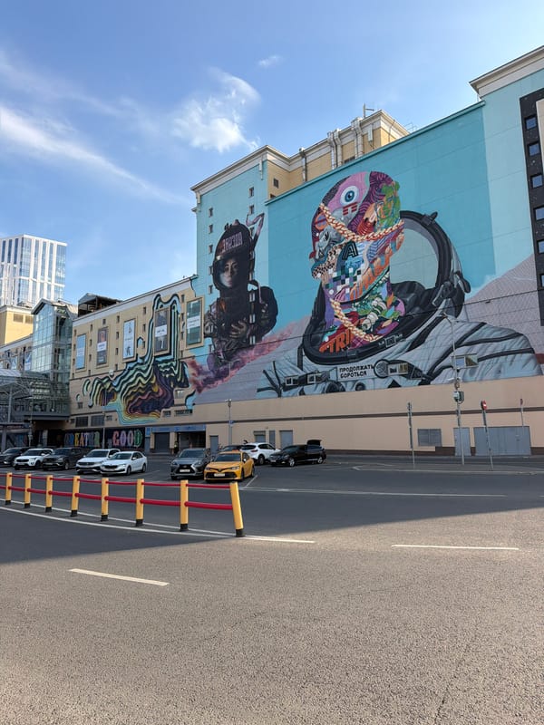 Street murals, metro escalators, and city movement on a July afternoon