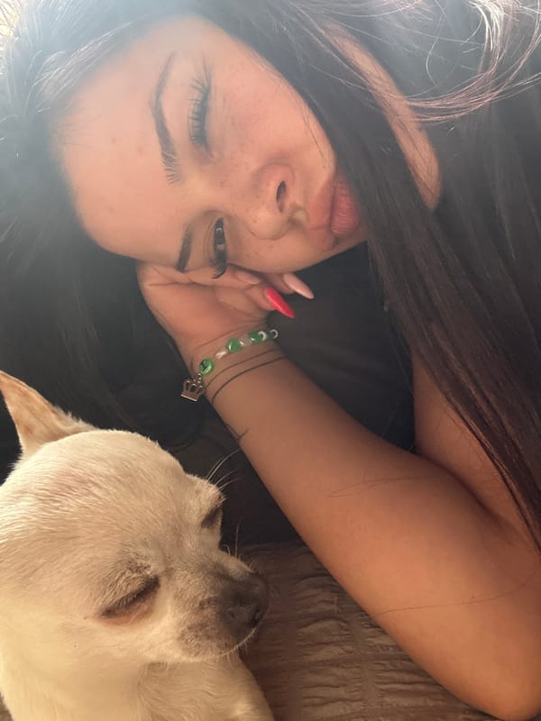 Woman takes selfies with white dog on sofa in Bulgaria