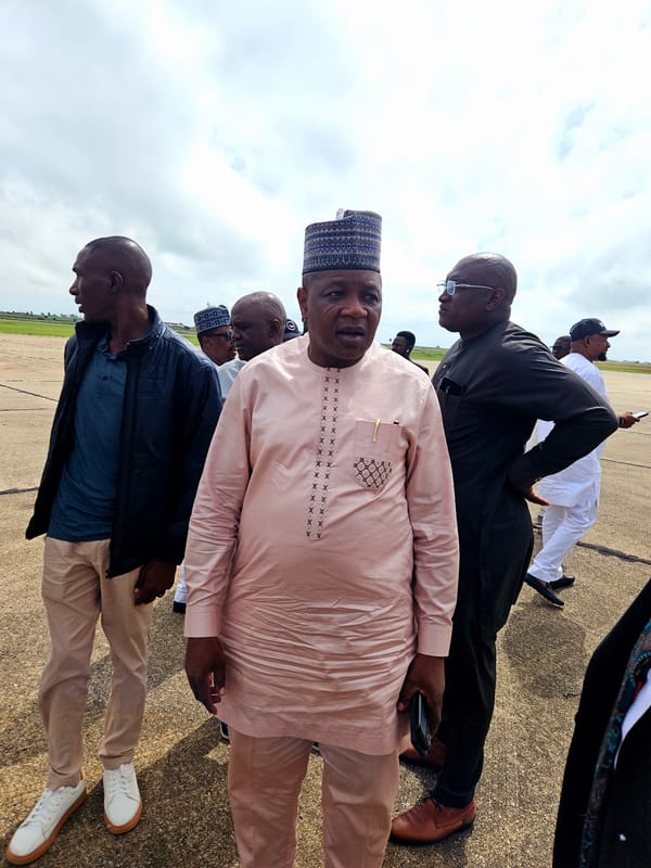 Group in traditional dress gathered around a private jet on tarmac