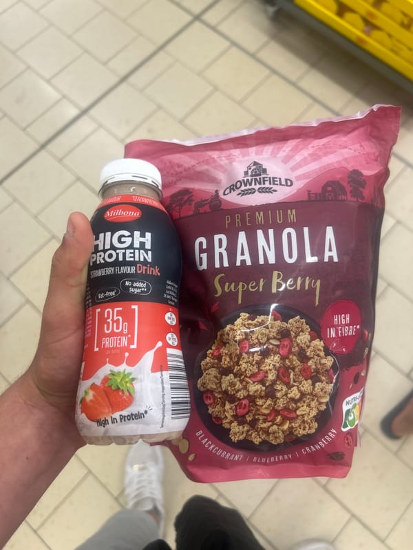 Shopper holds granola and protein drink in Ede store