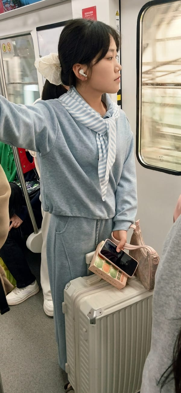 Woman rests on suitcase during subway journey in Chongqing