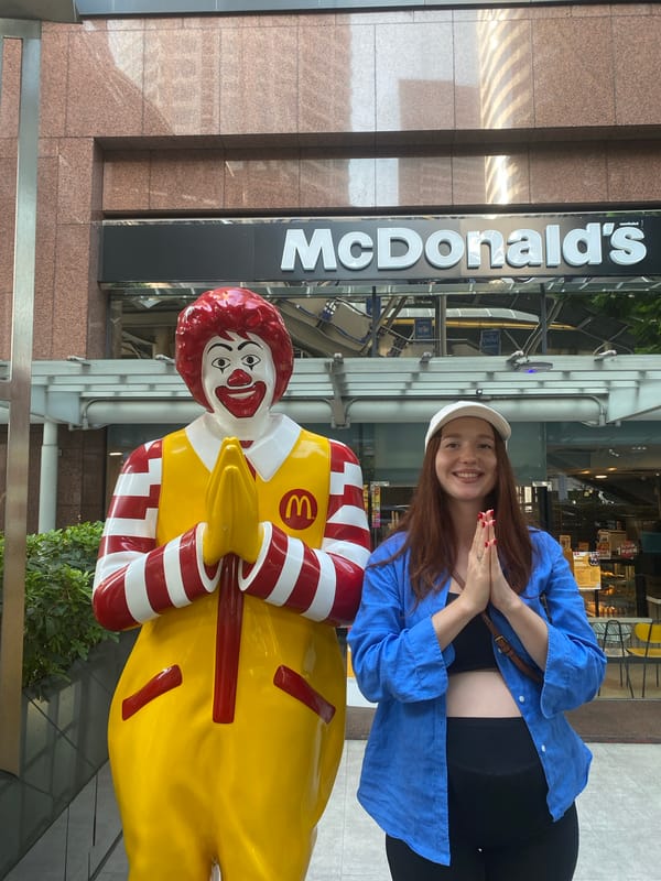 Tourist poses with Ronald McDonald statue in Bangkok