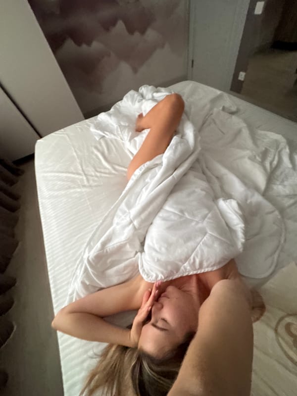 Resting in bed, white bedding, tulips nearby