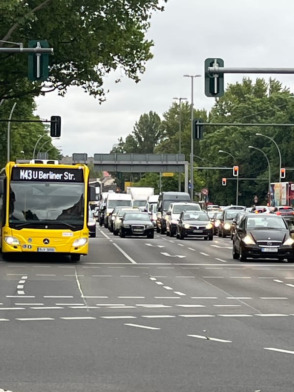 Berlin intersection activity with yellow buses and street life